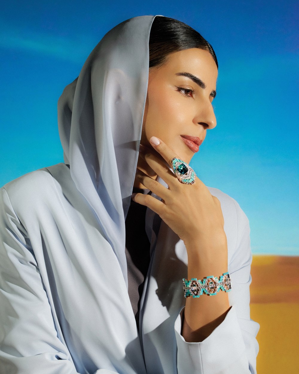 خاتم وسوار Exalting Joy.. من مجموعة Monsieur FRED Ideal Light، مجوهرات FRED.  عذاري ترتدي شيلة وعباية من Takara وفستاناً من Mimya 